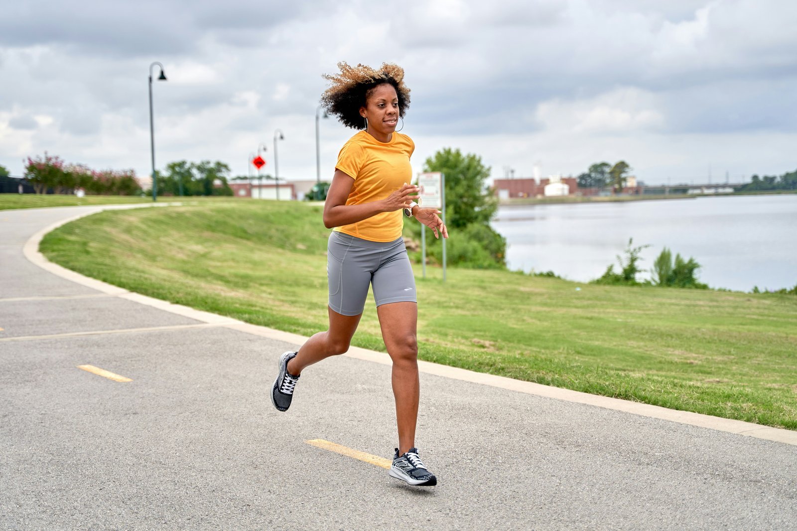 A woman running on a paved lakeside path