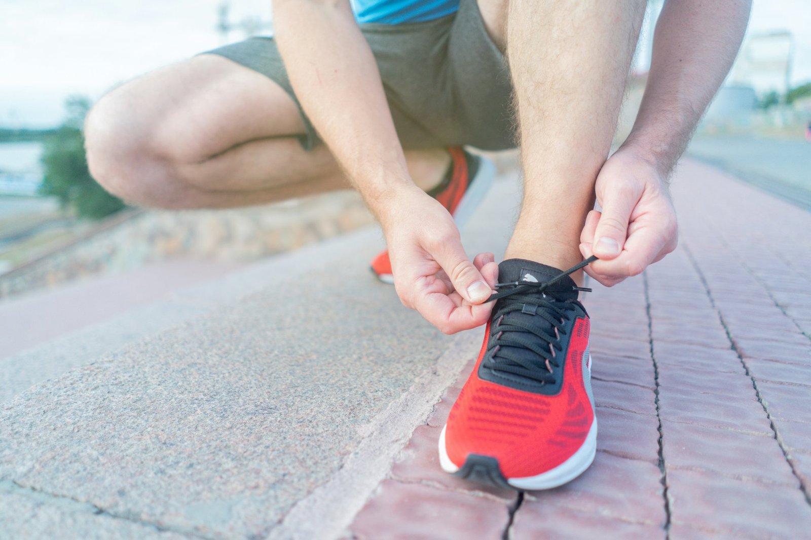 A runner lacing up their shoe before a run