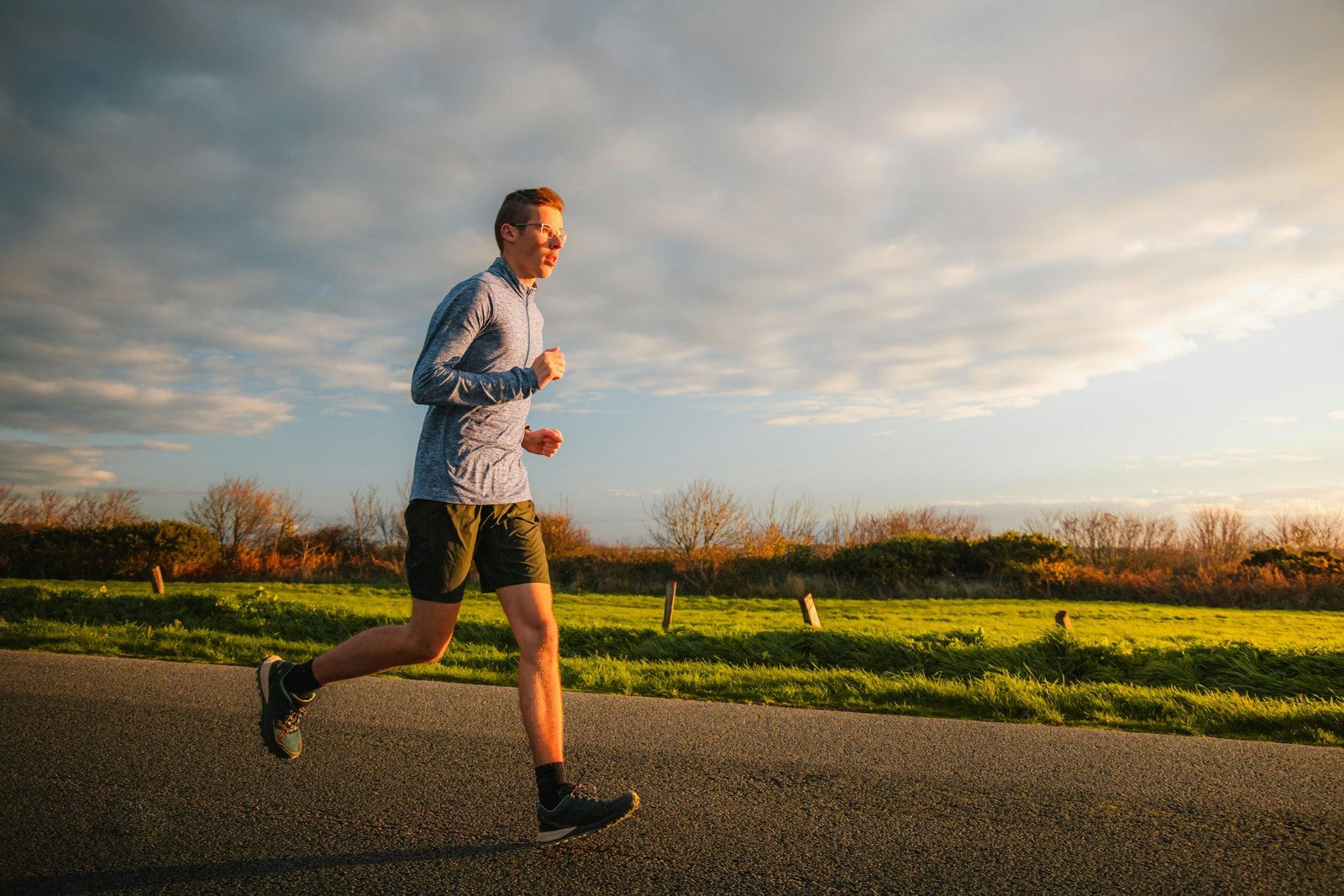 A runner moving steadily along a path at golden hour