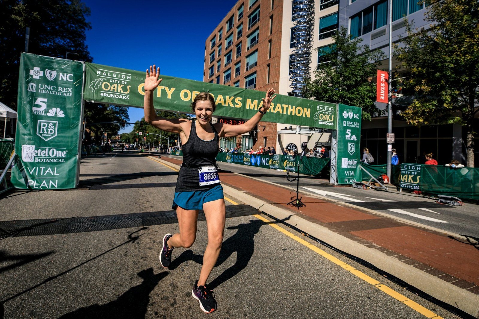 A runner finishing a marathon with arms raised in triumph