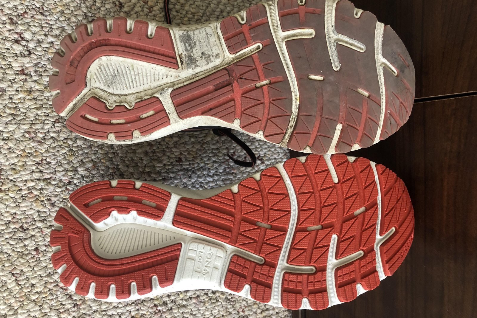 Worn running shoe sole next to a new one showing tread wear on running shoes for beginners
